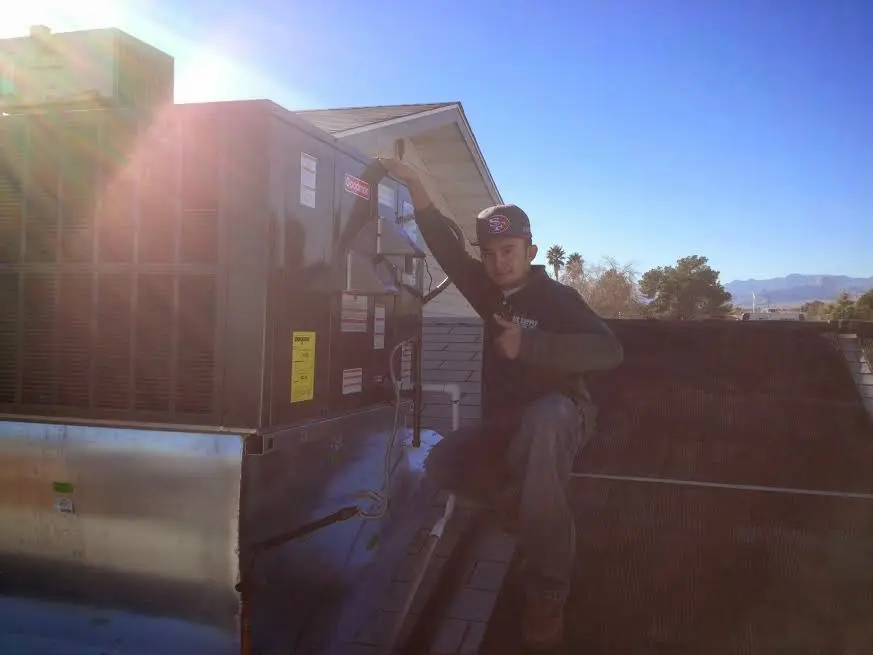 HVAC technician performing AC Tune-Up on a rooftop unit in Winter Haven